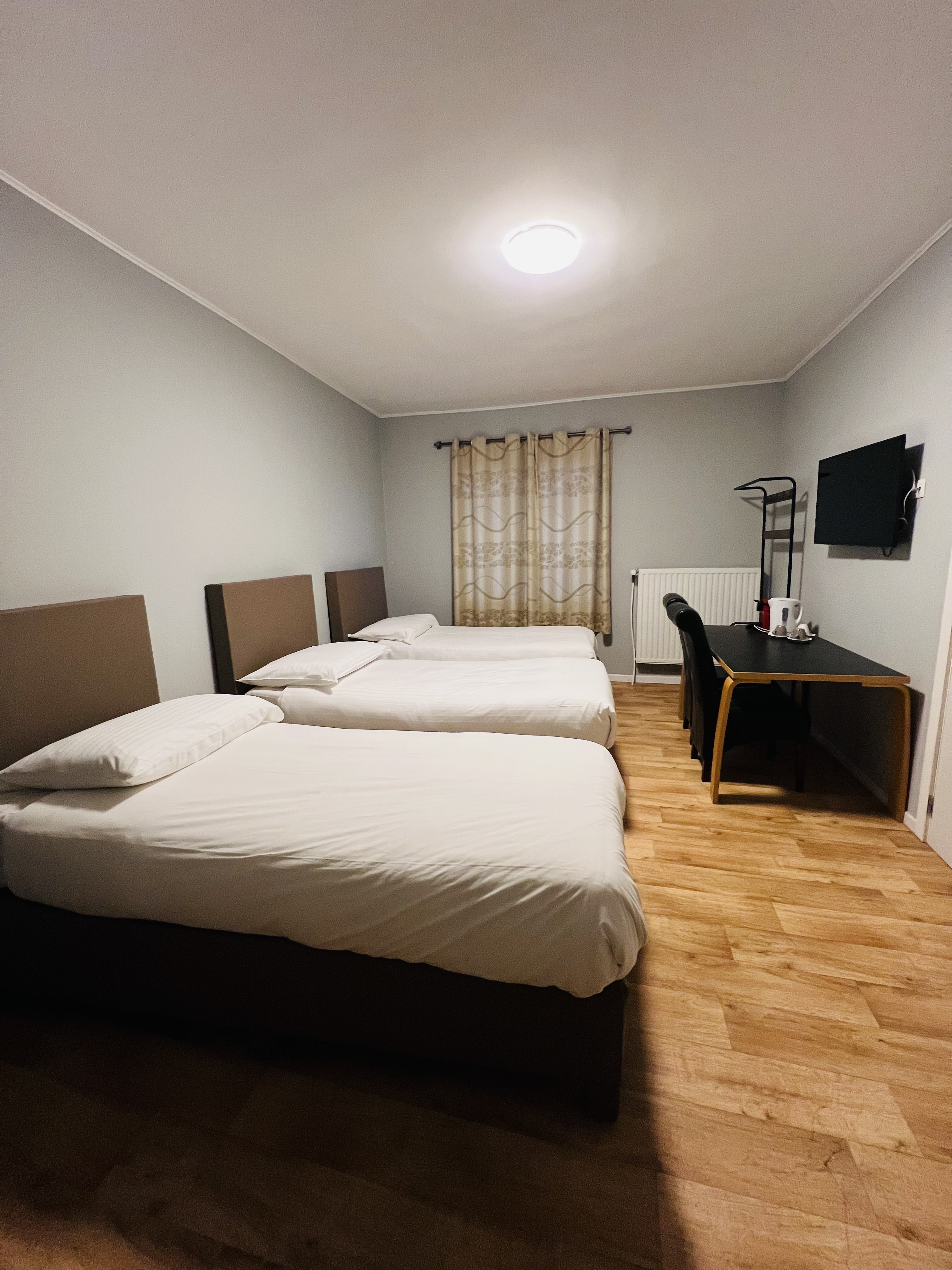 deluxe hotel suite bedroom with king bed, modern furniture, city view, elegant lighting