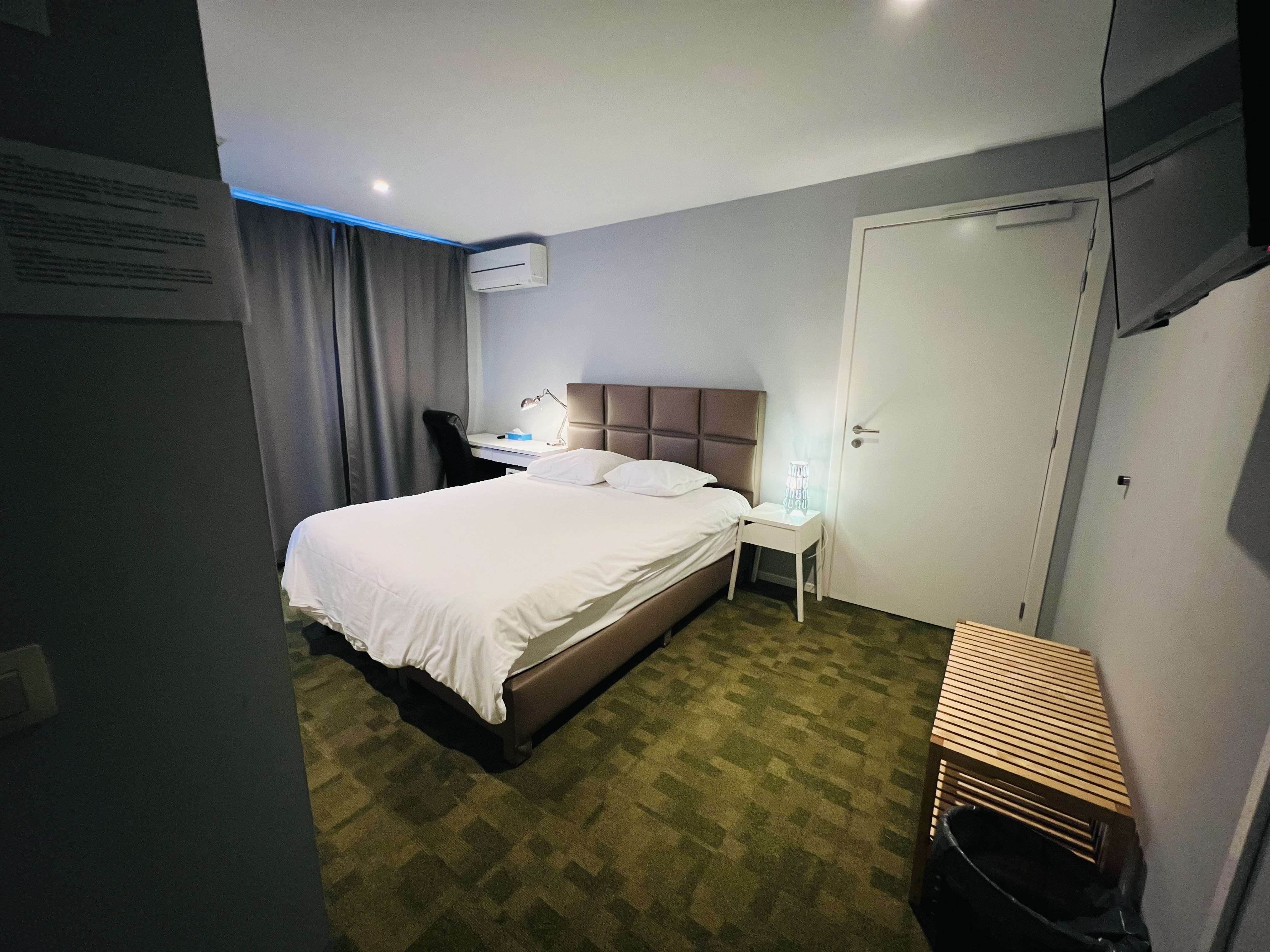 deluxe hotel suite bedroom with king bed, modern furniture, city view, elegant lighting