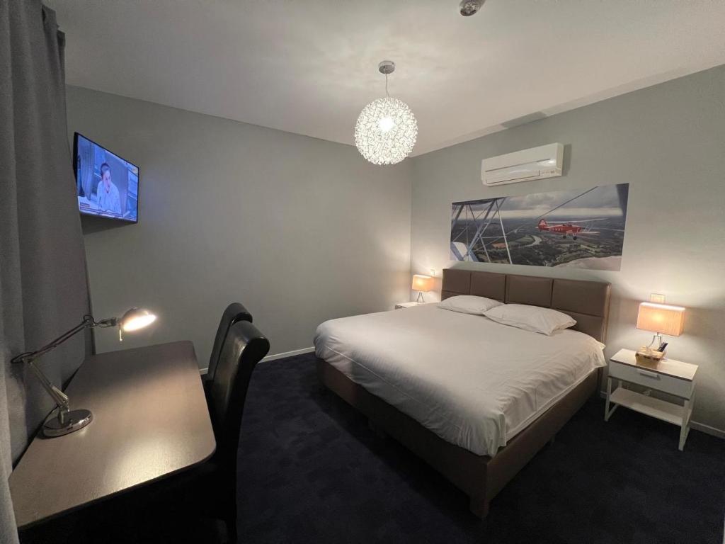 deluxe hotel suite bedroom with king bed, modern furniture, city view, elegant lighting