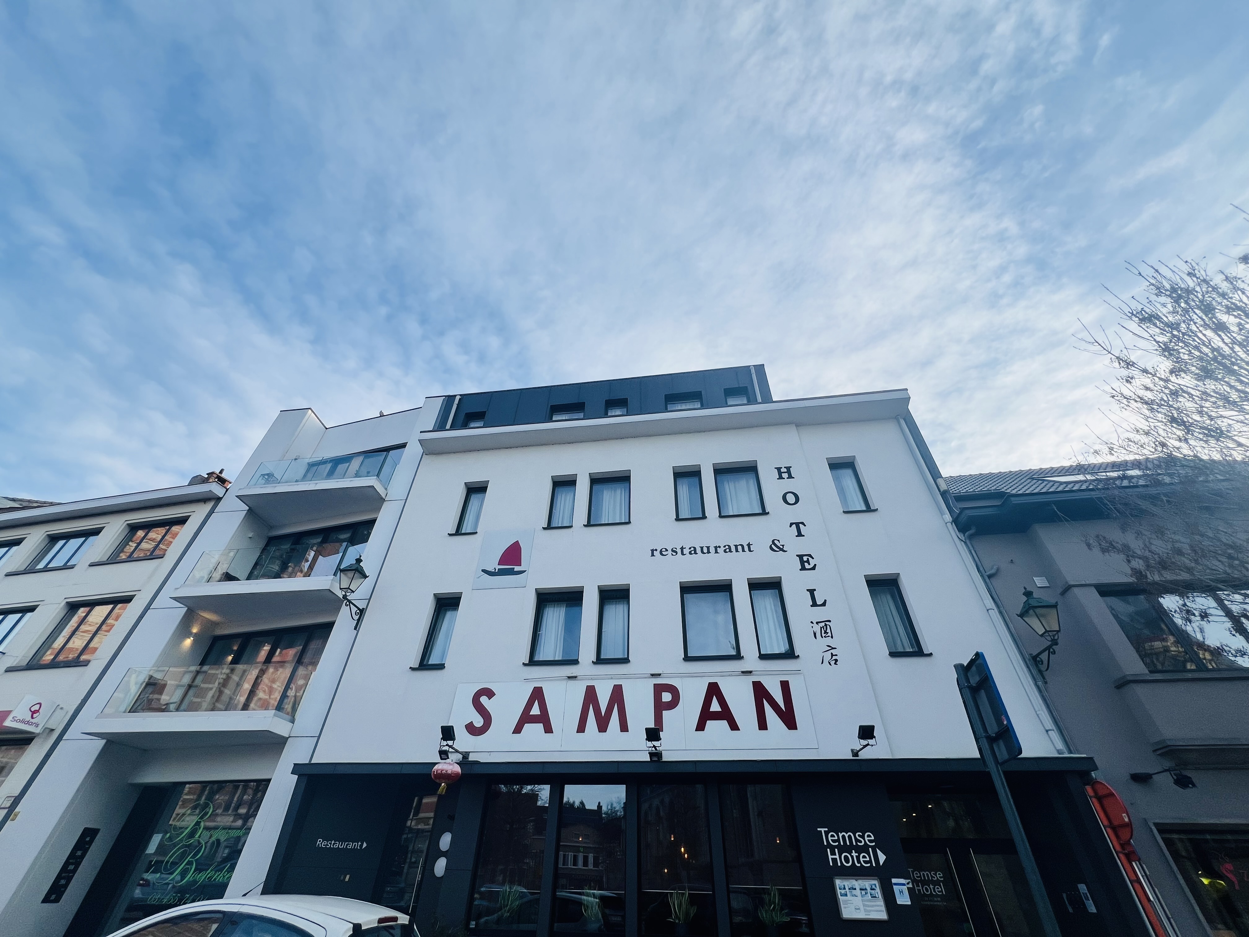 luxury hotel exterior facade with grand architecture, elegant entrance, manicured gardens, golden hour lighting